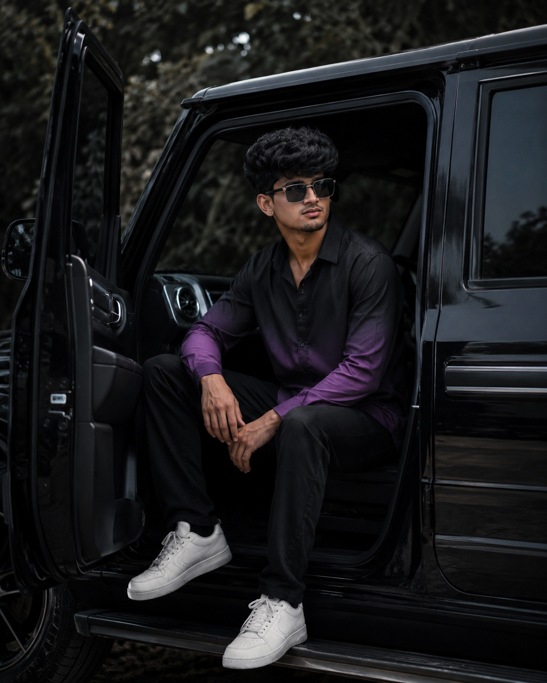 Cinematic portrait of a stylish man sitting in a black SUV with a moody background.
